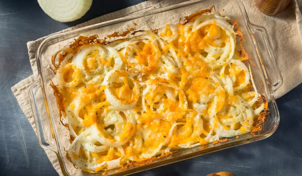 Homemade Tennessee onion casserole in a glass baking dish, featuring layers of sliced onions topped with melted cheddar cheese, beautifully browned and bubbly on the surface, indicative of a classic Tennessee onion recipe.